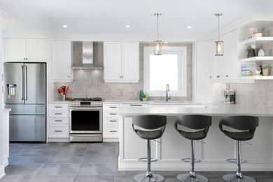 Transitional u-shaped gray floor kitchen photo in Toronto with an undermount sink, shaker cabinets, white cabinets, gray backsplash, stainless steel appliances, a peninsula and gray countertops