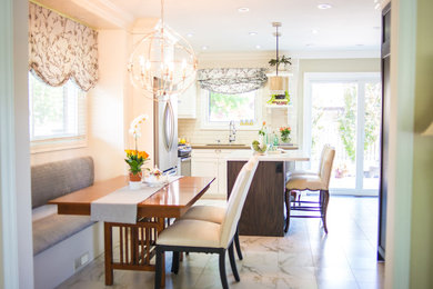 Mid-sized transitional l-shaped eat-in kitchen photo in Toronto with a double-bowl sink, shaker cabinets, white cabinets, white backsplash, subway tile backsplash, stainless steel appliances and an island