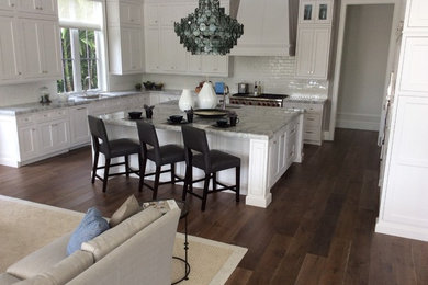 Open concept kitchen - mid-sized transitional u-shaped dark wood floor and brown floor open concept kitchen idea in Miami with an undermount sink, beaded inset cabinets, white cabinets, marble countertops, white backsplash, subway tile backsplash, stainless steel appliances and an island