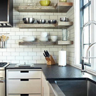 Example of a transitional kitchen design in Chicago with an undermount sink, flat-panel cabinets, white cabinets, white backsplash, subway tile backsplash and stainless steel appliances