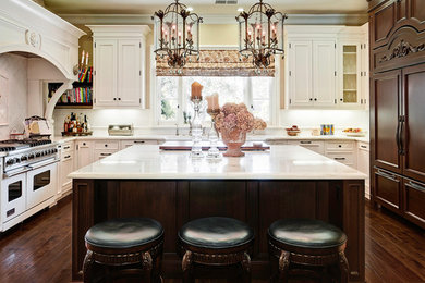 Inredning av ett klassiskt kök, med en rustik diskho, vita skåp, marmorbänkskiva, vitt stänkskydd, stänkskydd i keramik, mellanmörkt trägolv, en köksö, luckor med infälld panel och färgglada vitvaror