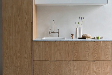 Inspiration for a small contemporary kitchen in Sussex with a belfast sink, flat-panel cabinets, medium wood cabinets, marble worktops and concrete flooring.