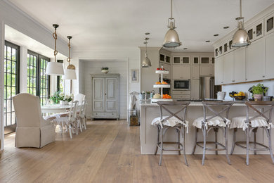 Example of a transitional l-shaped light wood floor eat-in kitchen design in Miami with shaker cabinets and beige cabinets