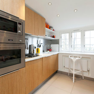 Esempio di una piccola cucina parallela minimal con lavello integrato, ante lisce, ante in legno chiaro, paraspruzzi a effetto metallico, elettrodomestici in acciaio inossidabile e nessuna isola