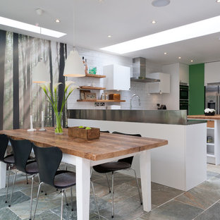 Inspiration for a mid-sized contemporary eat-in kitchen in Other with an integrated sink, flat-panel cabinets, white cabinets, wood benchtops, white splashback, stainless steel appliances, with island and subway tile splashback.