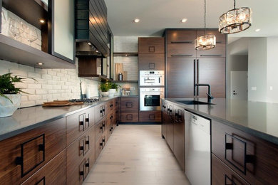 Eat-in kitchen - large industrial l-shaped light wood floor and beige floor eat-in kitchen idea in Other with an undermount sink, flat-panel cabinets, dark wood cabinets, soapstone countertops, white backsplash, brick backsplash, paneled appliances and an island