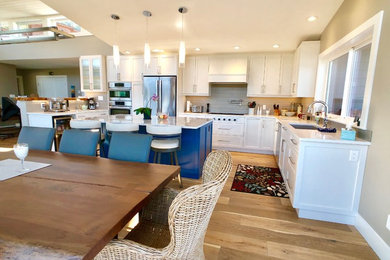 Eat-in kitchen - large coastal u-shaped medium tone wood floor and brown floor eat-in kitchen idea in Other with an undermount sink, shaker cabinets, white cabinets, quartz countertops, gray backsplash, subway tile backsplash, stainless steel appliances, an island and gray countertops