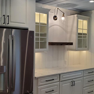 Example of a mid-sized farmhouse galley dark wood floor and brown floor eat-in kitchen design in Other with a farmhouse sink, shaker cabinets, white cabinets, quartz countertops, white backsplash, cement tile backsplash, stainless steel appliances and gray countertops