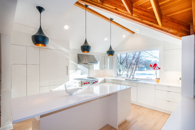 Mid-sized minimalist u-shaped light wood floor and brown floor eat-in kitchen photo in Other with an undermount sink, flat-panel cabinets, white cabinets, quartz countertops, white backsplash, porcelain backsplash, paneled appliances, an island and white countertops