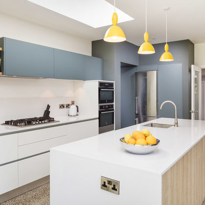 Example of a trendy l-shaped beige floor kitchen design in Other with an undermount sink, flat-panel cabinets, white cabinets, stainless steel appliances, an island and white countertops