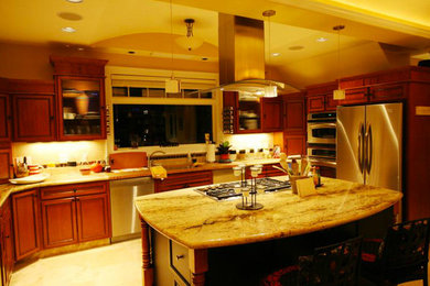 Modelo de cocina grande con puertas de armario de madera oscura, electrodomésticos de acero inoxidable y una isla