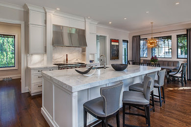 Eat-in kitchen - mid-sized transitional galley medium tone wood floor eat-in kitchen idea in Detroit with an undermount sink, recessed-panel cabinets, gray cabinets, marble countertops, gray backsplash, stone slab backsplash, stainless steel appliances and an island