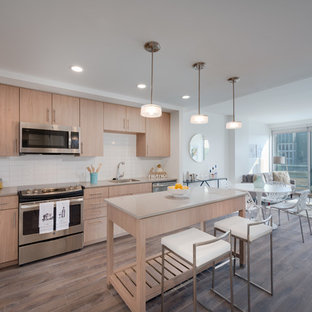 Mid-sized modern open concept kitchen ideas - Open concept kitchen - mid-sized modern l-shaped medium tone wood floor and brown floor open concept kitchen idea in DC Metro with an undermount sink, flat-panel cabinets, quartz countertops, glass tile backsplash, stainless steel appliances, light wood cabinets, white backsplash, an island and gray countertops