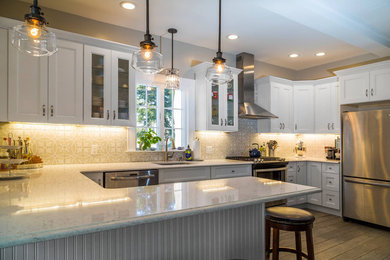 Example of a mid-sized transitional u-shaped ceramic tile and brown floor eat-in kitchen design with an undermount sink, shaker cabinets, white cabinets, quartz countertops, brown backsplash, porcelain backsplash, stainless steel appliances and a peninsula