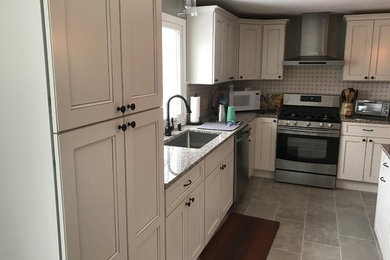 Mid-sized elegant l-shaped eat-in kitchen photo in Portland Maine with an undermount sink, shaker cabinets, white cabinets, granite countertops and an island