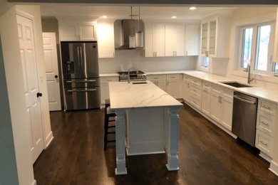 Eat-in kitchen - mid-sized transitional l-shaped dark wood floor and brown floor eat-in kitchen idea in Other with an undermount sink, shaker cabinets, white cabinets, quartz countertops, white backsplash, subway tile backsplash, stainless steel appliances, an island and white countertops