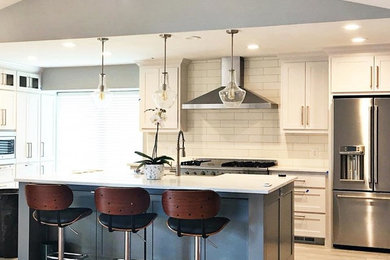 Inspiration for a mid-sized modern galley porcelain tile and gray floor eat-in kitchen remodel in Dallas with a farmhouse sink, raised-panel cabinets, gray cabinets, quartz countertops, white backsplash, ceramic backsplash, stainless steel appliances and an island
