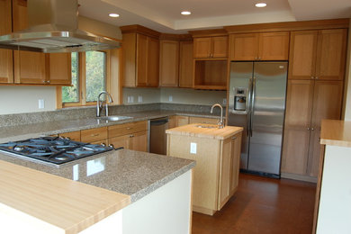 Bild på ett avskilt, mellanstort amerikanskt kök, med en undermonterad diskho, skåp i shakerstil, skåp i ljust trä, granitbänkskiva, rostfria vitvaror, ljust trägolv och en köksö