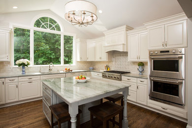 Inspiration for a large timeless u-shaped medium tone wood floor enclosed kitchen remodel in DC Metro with an island, an undermount sink, raised-panel cabinets, white cabinets, quartzite countertops, gray backsplash, ceramic backsplash and stainless steel appliances