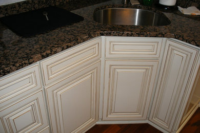 Inspiration för ett funkis kök, med en undermonterad diskho, luckor med upphöjd panel, beige skåp, granitbänkskiva och mellanmörkt trägolv