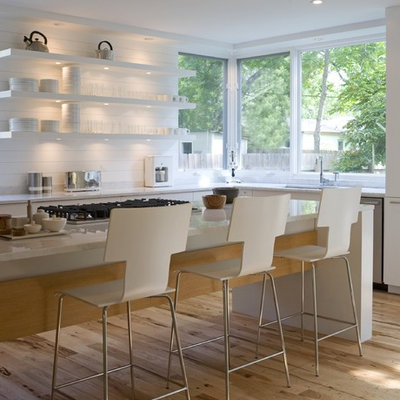 Kitchen - mid-sized modern galley medium tone wood floor kitchen idea in Austin with marble countertops, open cabinets, white cabinets, white backsplash, stainless steel appliances and an island