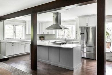 Eat-in kitchen - large transitional l-shaped medium tone wood floor and brown floor eat-in kitchen idea in Other with a farmhouse sink, beaded inset cabinets, white cabinets, quartzite countertops, white backsplash, marble backsplash, stainless steel appliances, an island and white countertops