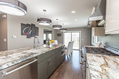 Example of a mid-sized transitional galley medium tone wood floor and gray floor eat-in kitchen design in Other with an undermount sink, flat-panel cabinets, white cabinets, granite countertops, stainless steel appliances and an island