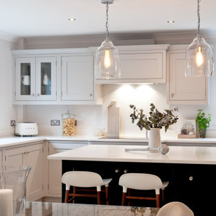 Design ideas for a medium sized traditional l-shaped kitchen/diner in Kent with shaker cabinets, grey cabinets, quartz worktops, white splashback, stainless steel appliances, an island and white worktops.