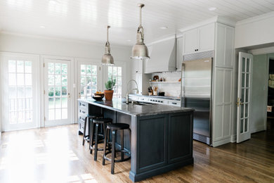 Example of a mid-sized trendy single-wall medium tone wood floor, brown floor and shiplap ceiling eat-in kitchen design in Other with an undermount sink, beaded inset cabinets, gray cabinets, granite countertops, white backsplash, marble backsplash, stainless steel appliances, an island and black countertops