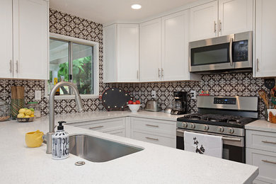 Example of a mid-sized trendy u-shaped open concept kitchen design in Other with a single-bowl sink, recessed-panel cabinets, white cabinets, quartz countertops, multicolored backsplash, ceramic backsplash, stainless steel appliances and a peninsula