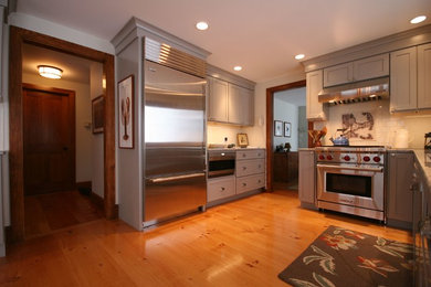 Modelo de cocina campestre con fregadero bajoencimera, armarios estilo shaker, puertas de armario grises, encimera de granito y salpicadero blanco