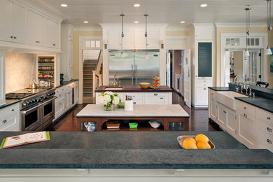 サンフランシスコにある広いトラディショナルスタイルのおしゃれなキッチン (エプロンフロントシンク、シェーカースタイル扉のキャビネット、白いキャビネット、シルバーの調理設備、濃色無垢フローリング、茶色い床) の写真