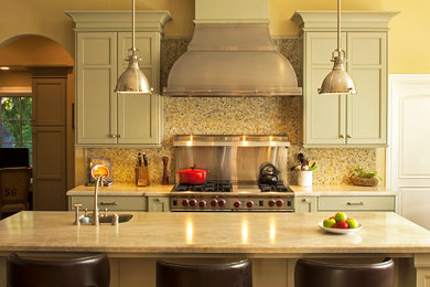 Idéer för ett klassiskt kök, med en undermonterad diskho, luckor med infälld panel, gröna skåp, granitbänkskiva, flerfärgad stänkskydd, stänkskydd i glaskakel, rostfria vitvaror, mellanmörkt trägolv och en köksö