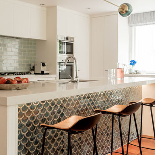 Idee per una piccola cucina contemporanea con ante lisce, ante bianche, top in marmo, paraspruzzi verde, paraspruzzi con piastrelle a mosaico, elettrodomestici in acciaio inossidabile, pavimento in legno massello medio, pavimento marrone, lavello sottopiano e top bianco
