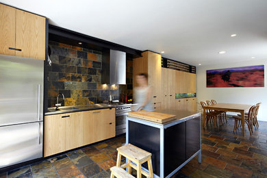 メルボルンにある小さなコンテンポラリースタイルのおしゃれなキッチン (一体型シンク、ステンレスカウンター、石タイルのキッチンパネル、シルバーの調理設備、スレートの床) の写真