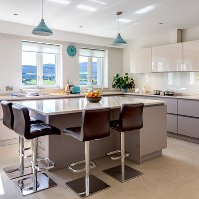 Inspiration for a large contemporary l-shaped porcelain tile and beige floor kitchen remodel in Dublin with flat-panel cabinets, quartzite countertops, glass sheet backsplash, paneled appliances, an island, white backsplash and an undermount sink