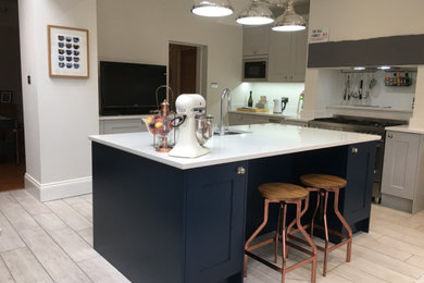 Inspiration for a large industrial u-shaped kitchen/diner in Other with a built-in sink, shaker cabinets, blue cabinets, quartz worktops, stainless steel appliances, porcelain flooring, an island, grey floors and white worktops.