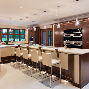 Foto de cocina comedor en L, contemporánea, grande, con fregadero bajoencimera, armarios con paneles lisos, puertas de armario de madera en tonos medios, encimera de cuarcita, electrodomésticos de acero inoxidable, suelo de piedra caliza y una isla