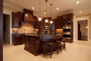 Example of a large classic u-shaped marble floor eat-in kitchen design in Newark with a farmhouse sink, raised-panel cabinets, dark wood cabinets, granite countertops, beige backsplash, mosaic tile backsplash, stainless steel appliances and an island