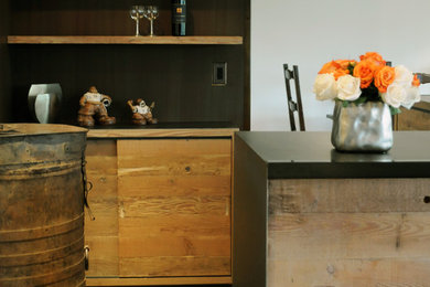 他の地域にあるコンテンポラリースタイルのおしゃれなキッチン (淡色木目調キャビネット、黒いキッチンパネル) の写真