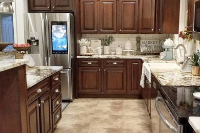 Inspiration for a large country l-shaped open concept kitchen remodel in Chicago with a farmhouse sink, raised-panel cabinets, dark wood cabinets, terrazzo countertops, white backsplash, subway tile backsplash, stainless steel appliances and an island