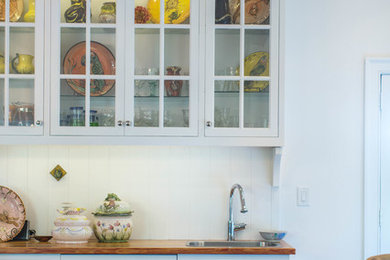 Immagine di una cucina chic di medie dimensioni con lavello da incasso, ante a filo, ante bianche, top in legno, paraspruzzi bianco, elettrodomestici da incasso, pavimento in ardesia e pavimento multicolore