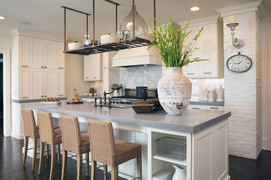 Eat-in kitchen - mid-sized cottage single-wall dark wood floor eat-in kitchen idea in Oklahoma City with an undermount sink, shaker cabinets, white cabinets, quartz countertops, white backsplash, stone slab backsplash, stainless steel appliances and an island