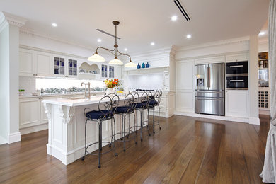 Klassische Küche in U-Form mit weißen Schränken, Küchenrückwand in Weiß, Küchengeräten aus Edelstahl und Kücheninsel in Sydney