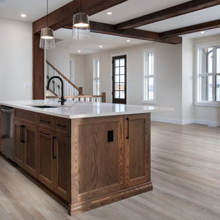 Mid-sized country l-shaped kitchen pantry in Edmonton with an undermount sink, shaker cabinets, medium wood cabinets, quartz benchtops, white splashback, ceramic splashback, stainless steel appliances, vinyl floors, with island, beige floor and white benchtop.
