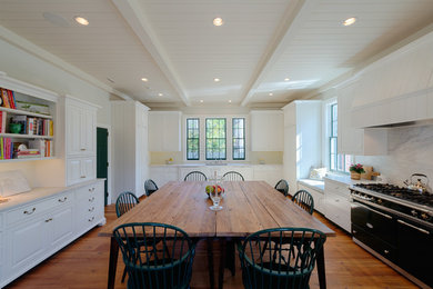 Eat-in kitchen - large farmhouse single-wall medium tone wood floor eat-in kitchen idea in Charlotte with a double-bowl sink, white cabinets, marble countertops, white backsplash, stone slab backsplash, colored appliances and no island