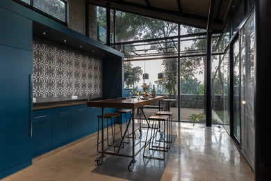 Aménagement d'une cuisine contemporaine de taille moyenne avec des portes de placard bleues.
