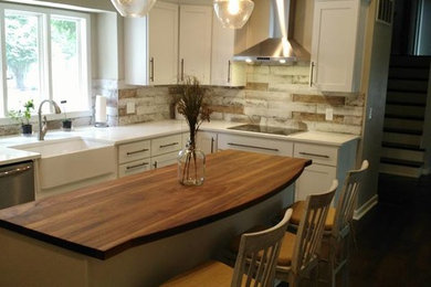 Inspiration for a mid-sized transitional l-shaped dark wood floor and brown floor eat-in kitchen remodel in Other with a farmhouse sink, shaker cabinets, white cabinets, wood countertops, gray backsplash, marble backsplash, stainless steel appliances and an island