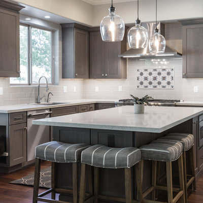 Eat-in kitchen - mid-sized farmhouse u-shaped dark wood floor and brown floor eat-in kitchen idea in Phoenix with an undermount sink, shaker cabinets, dark wood cabinets, solid surface countertops, white backsplash, subway tile backsplash, stainless steel appliances, an island and white countertops