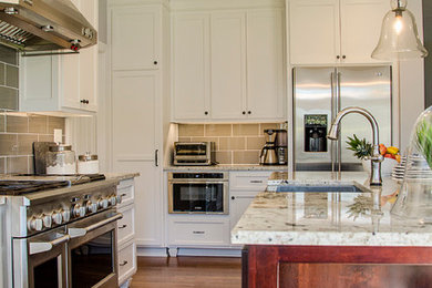 Eat-in kitchen - mid-sized farmhouse l-shaped medium tone wood floor eat-in kitchen idea in Richmond with a farmhouse sink, shaker cabinets, white cabinets, granite countertops, gray backsplash, ceramic backsplash, stainless steel appliances and an island